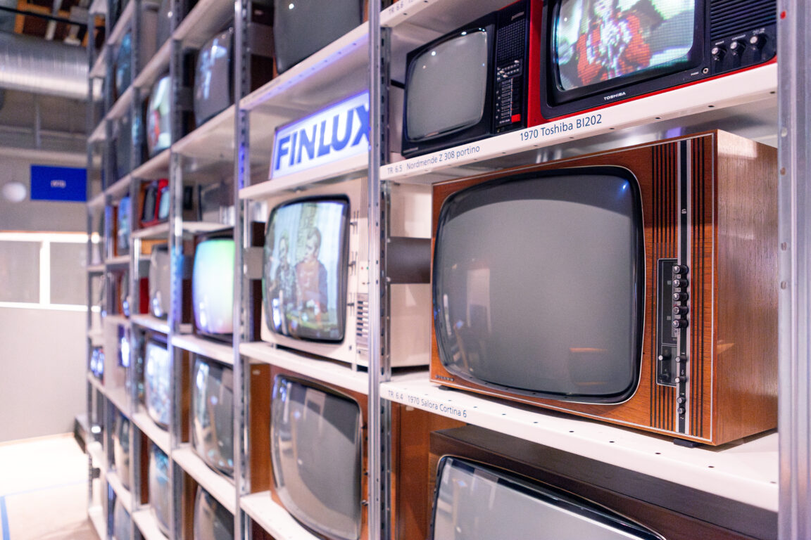 Vanhoja televisioita hyllyillä.