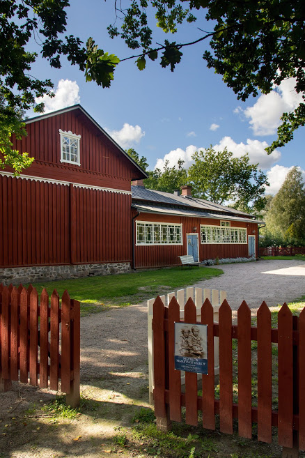 Meritalon museon aita ja avoin portti. Taustalla punainen museorakennus