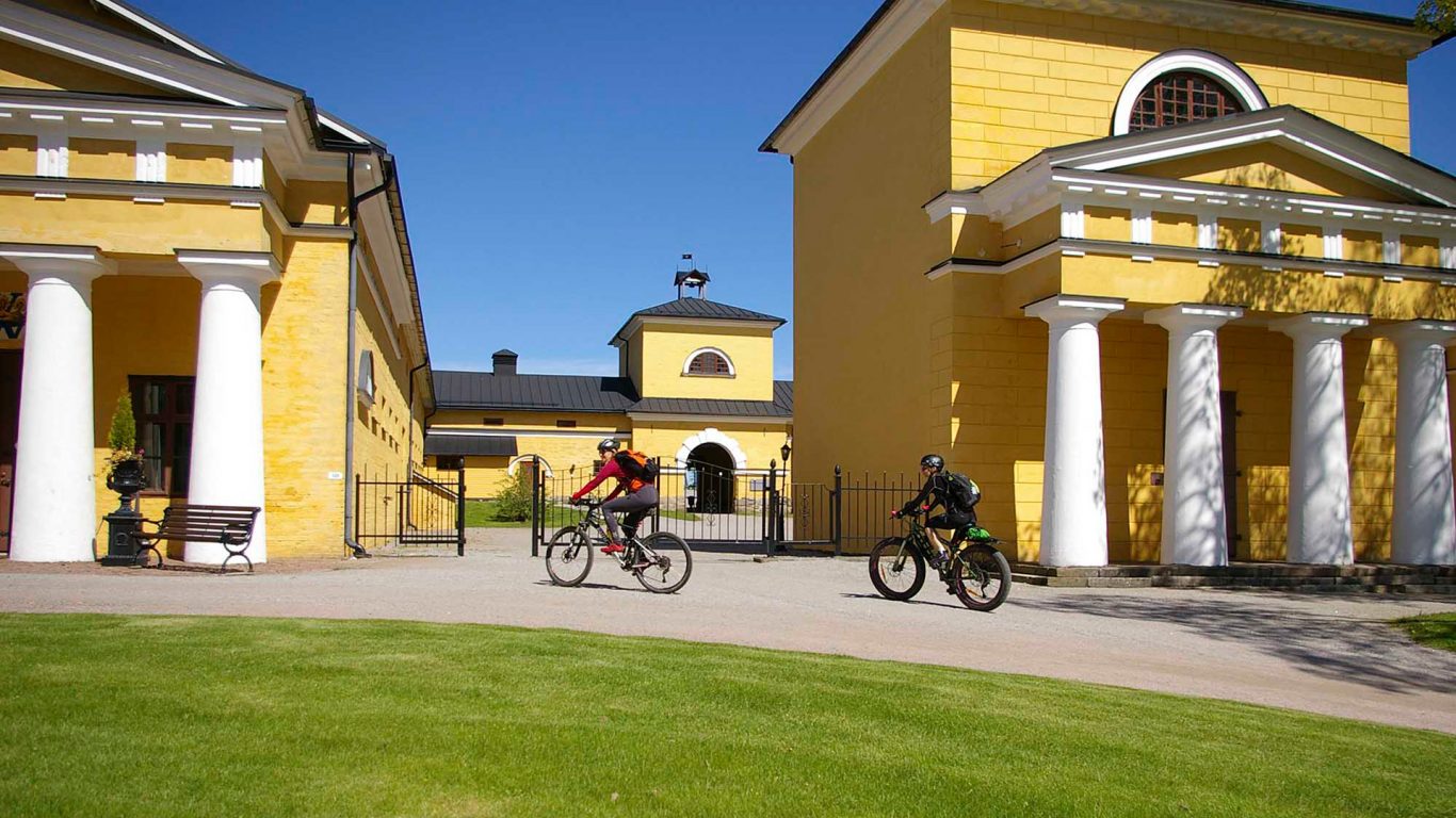 Two people on bicycles in front of Wiurila manor