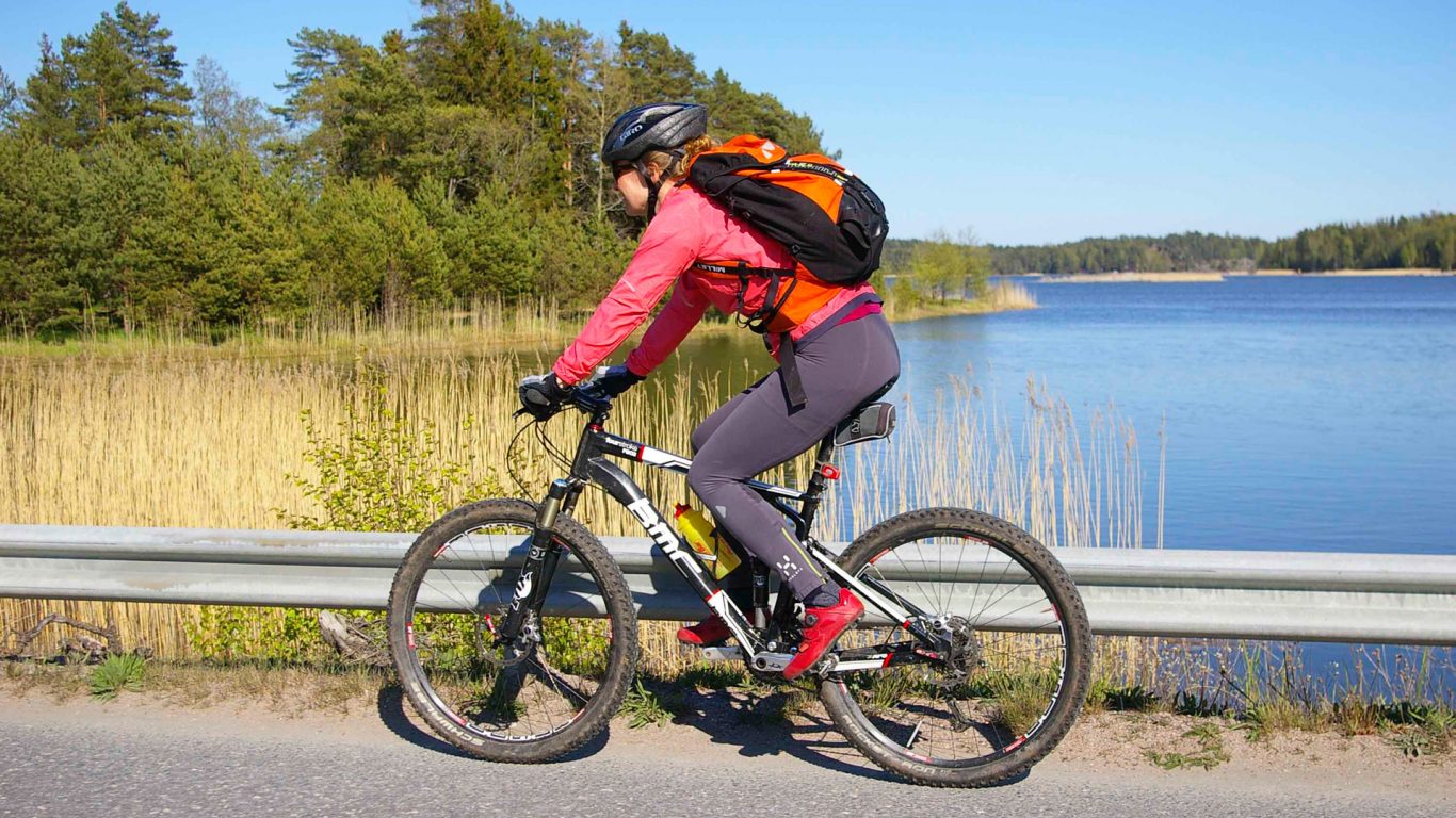 Woman on a bicycle on the coastal route in front of sea